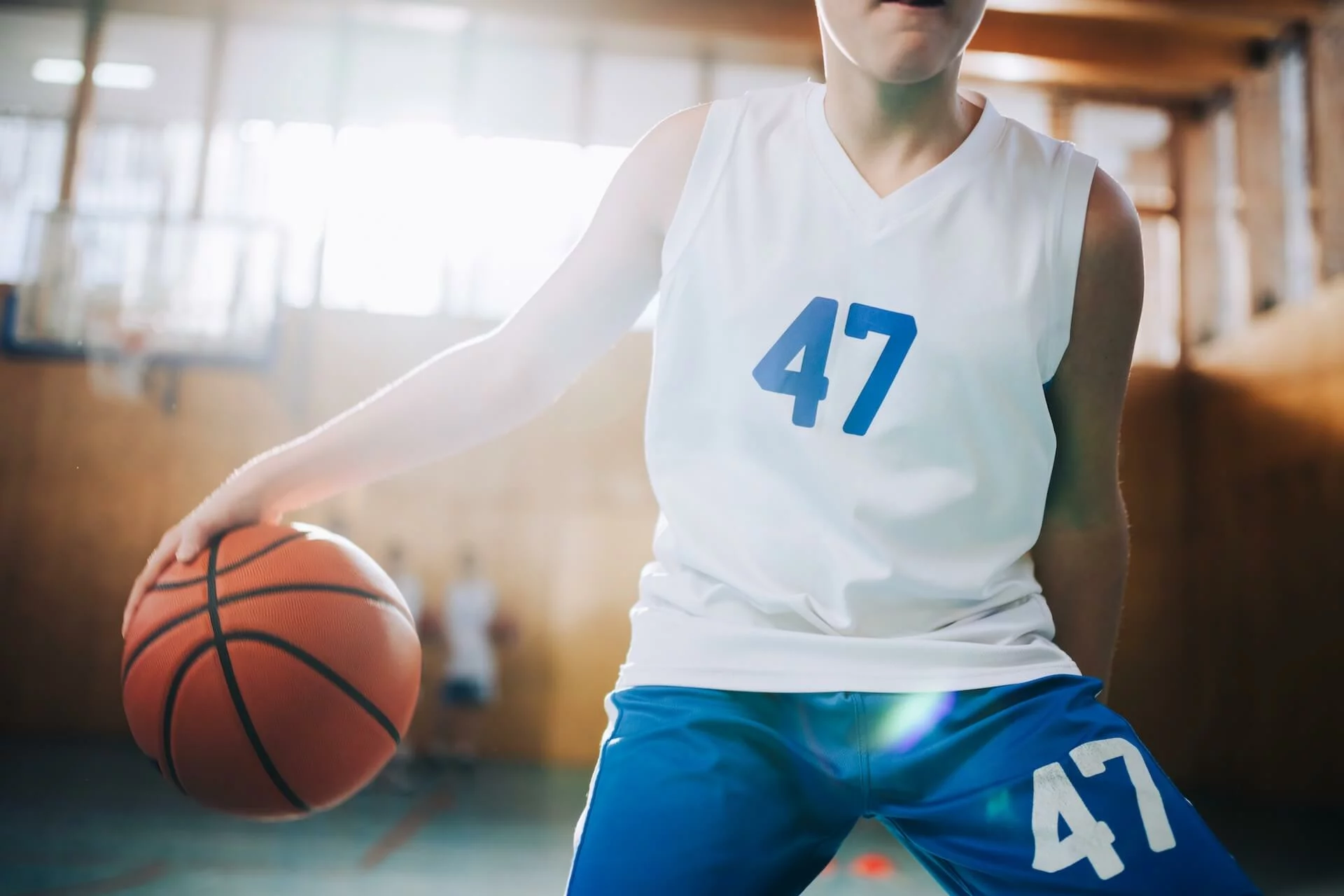 Joueur de basket jonglant avec un ballon dans un gymnase — shooting photo sport Stardust Communication