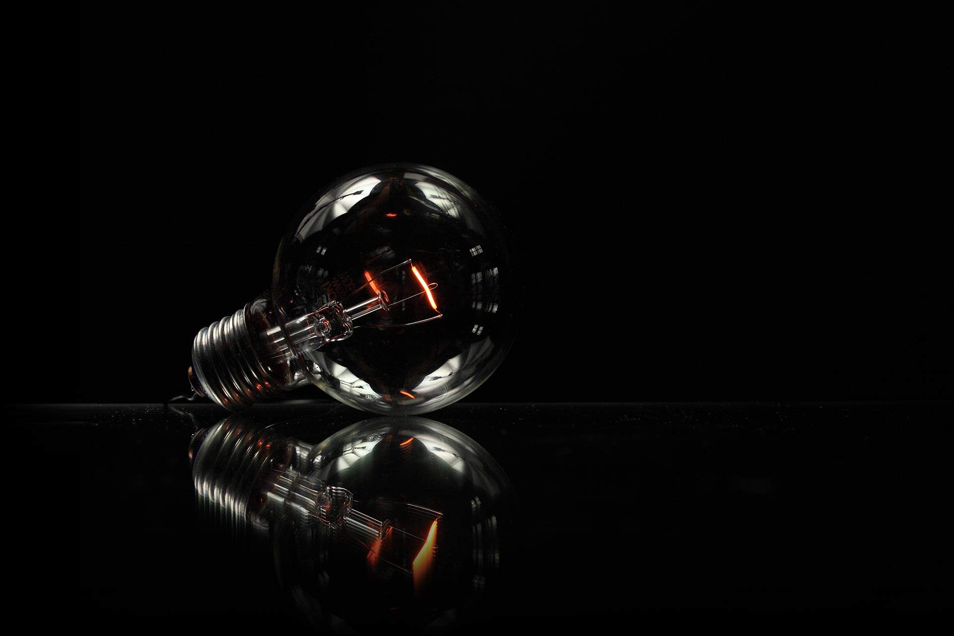 Ampoule sur fond sombre — thème page agence Stardust Communication